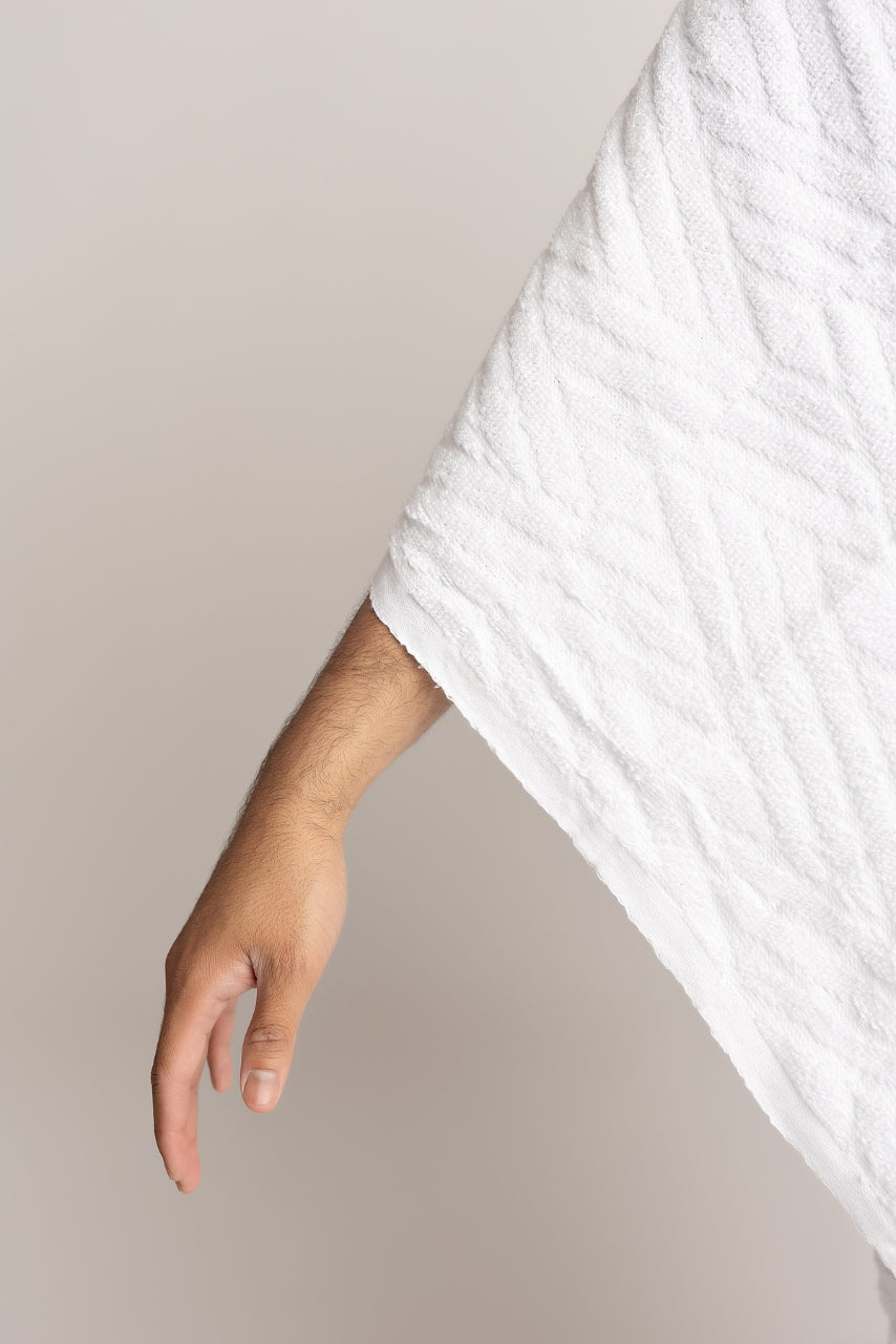 A close up photo of an arm covered with a white ihram from the halal caravan