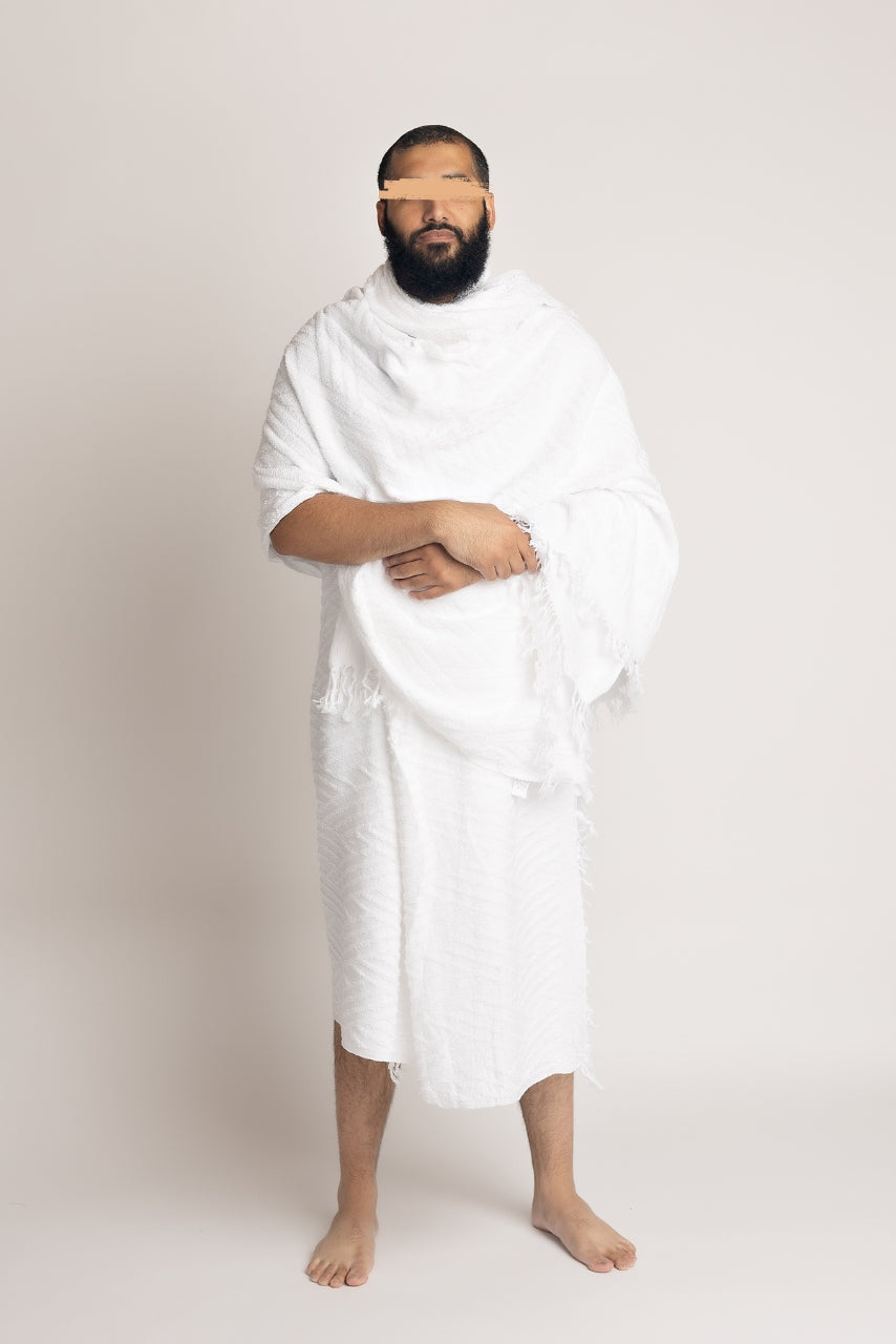 A front pose photo of a  muslim man wearing a two piece mens white ihram set from the halal caravan